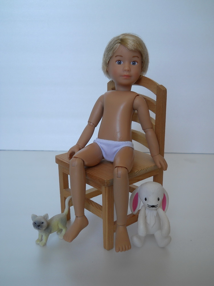 кукла Крузелингс сидит на стуле